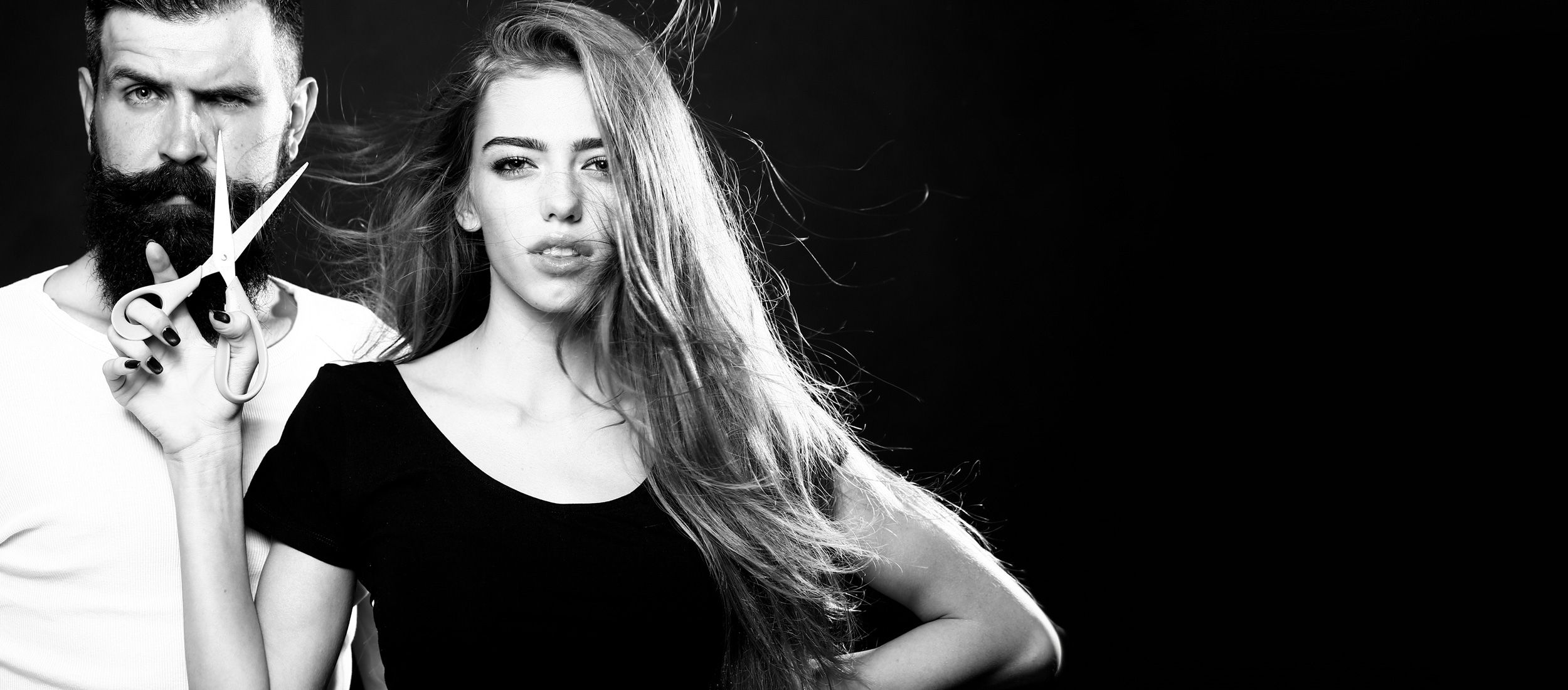 Ein Mann und eine Frau mit einer Schere in der Hand, bereit, etwas zu schneiden.